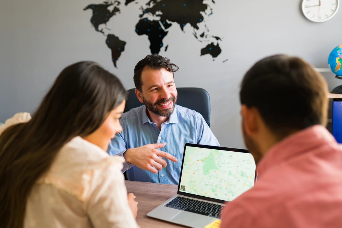 Team analyzing travel data on a laptop with a world map in the background.